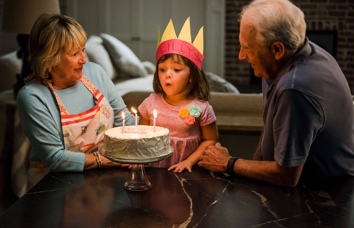 grandparents blowing cake with grandchildren