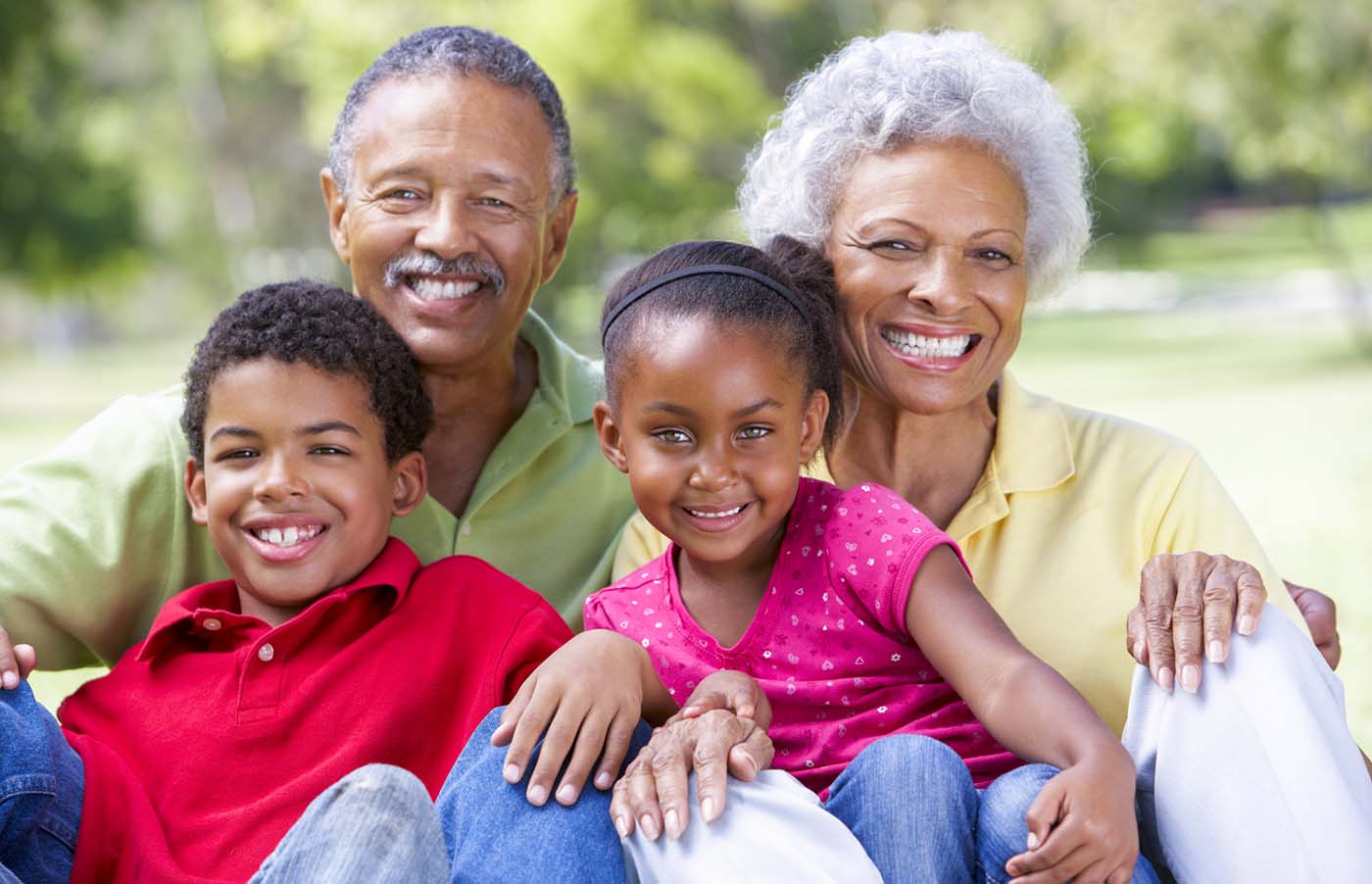 Grandparents sitting outside with their granddaughter and grandson
