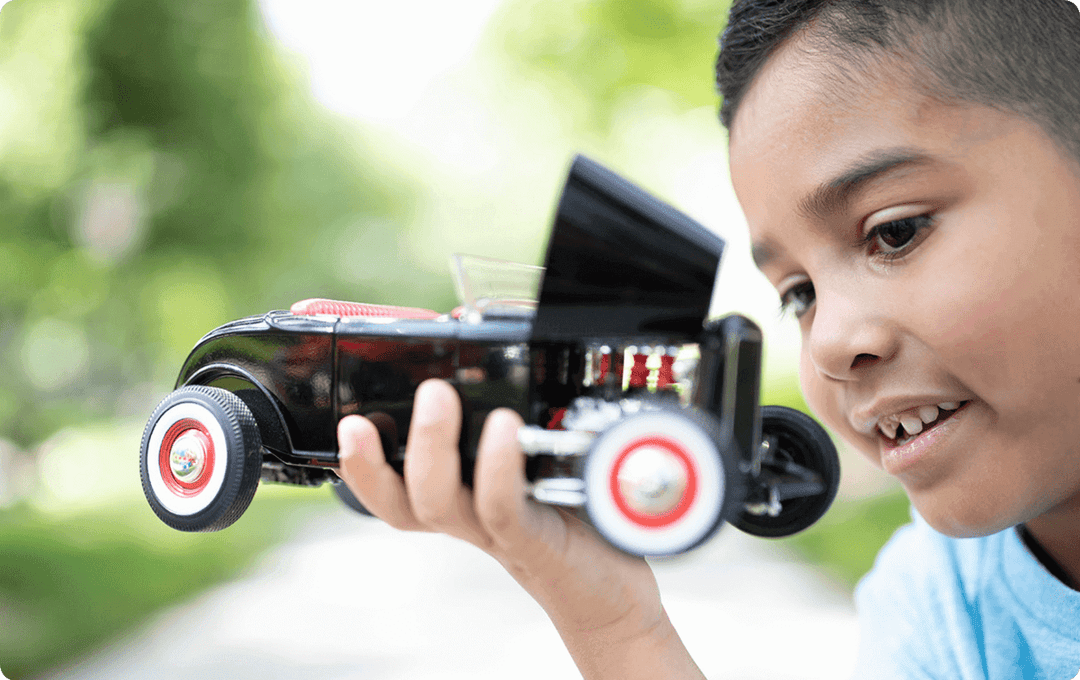 A boy holding a model car toy