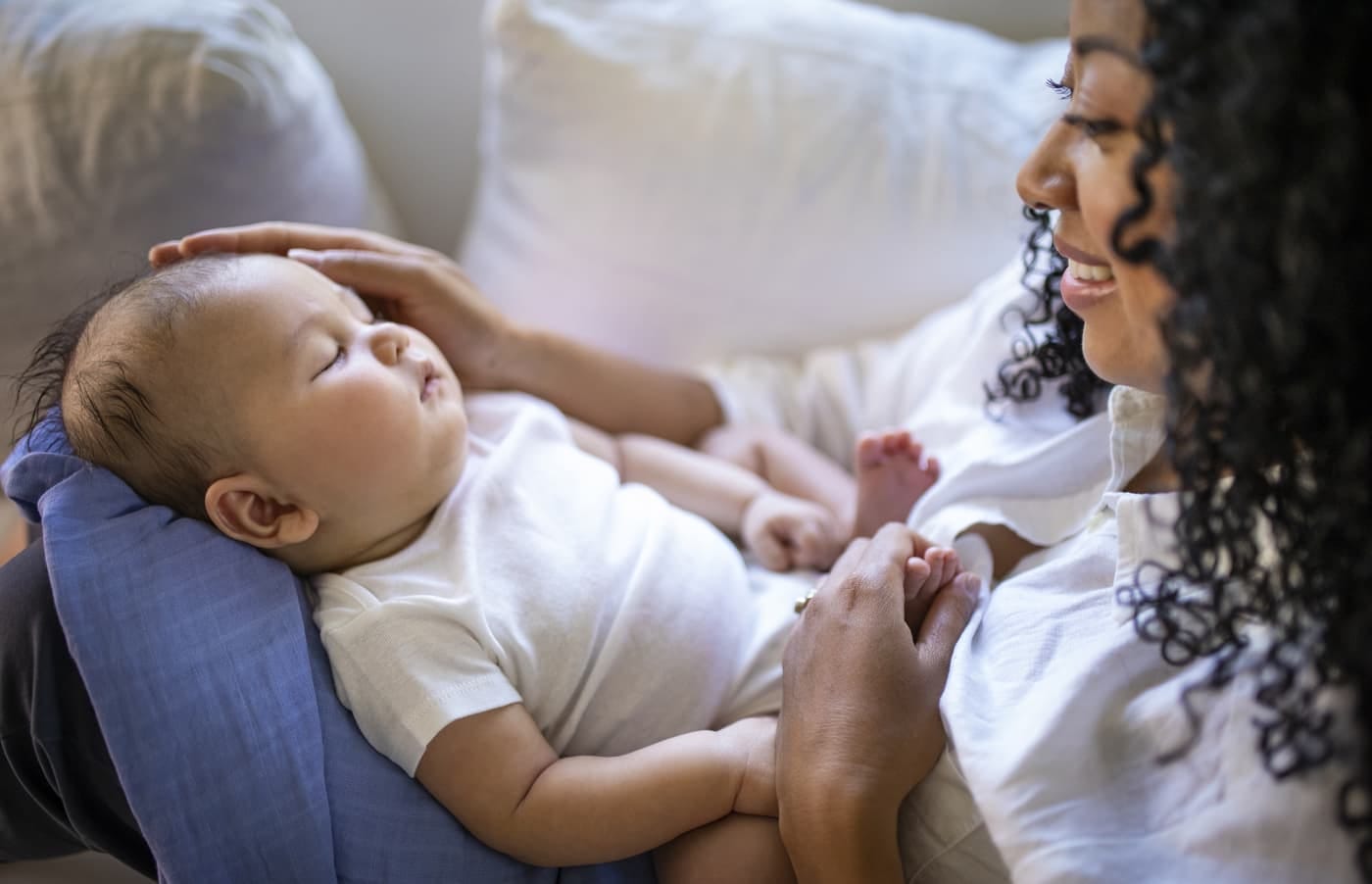 A mom watching her baby sleep on her lap