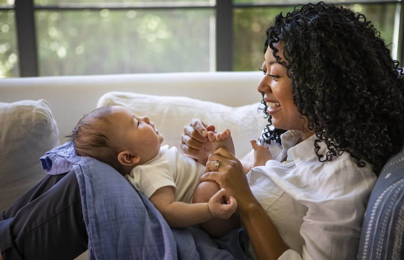 A mom with a baby on her lap playing with their feet
